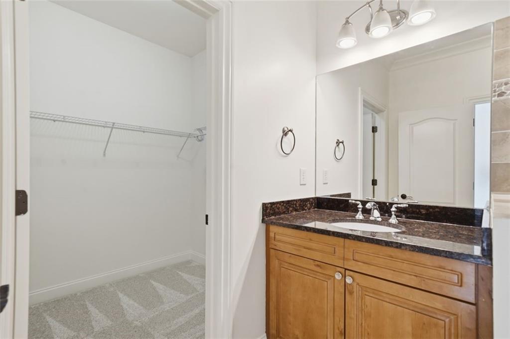 7611 Regency Circle Sandy Springs, GA 30350 - Photo 37 of 74 a bathroom with a granite countertop sink and a mirror