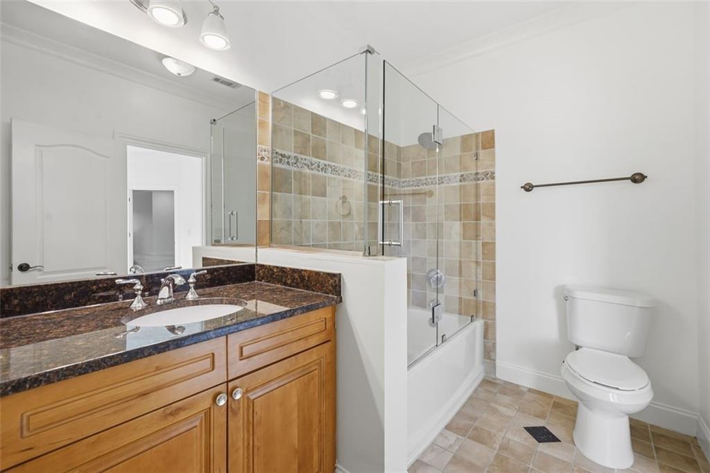 7611 Regency Circle Sandy Springs, GA 30350 - Photo 38 of 74 a bathroom with a granite countertop sink a toilet a mirror and shower
