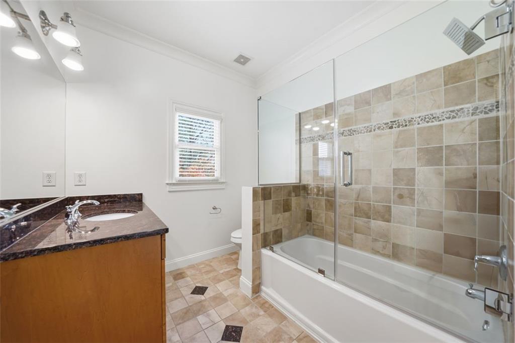 7611 Regency Circle Sandy Springs, GA 30350 - Photo 49 of 74 a bathroom with a granite countertop sink a toilet a bathtub and shower