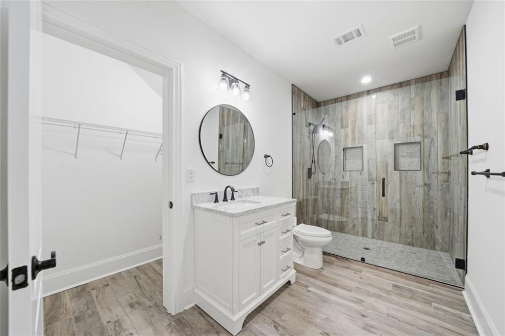 7611 Regency Circle Sandy Springs, GA 30350 - Photo 52 of 74 a bathroom with a double vanity sink toilet mirror and shower