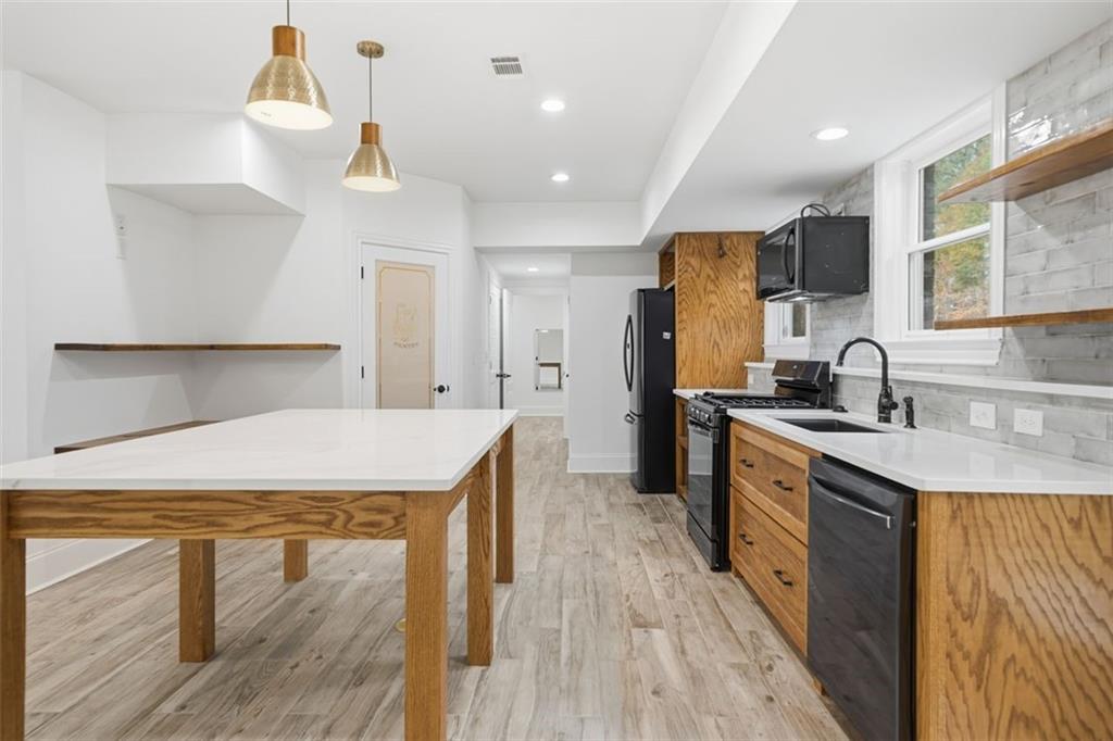 7611 Regency Circle Sandy Springs, GA 30350 - Photo 60 of 74 a kitchen with kitchen island a sink appliances and cabinets