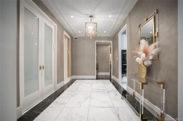 a very nice looking hallway with a large mirror and chandelier