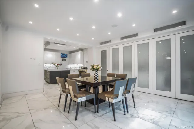 a view of a dining room and livingroom with furniture a rug a painting and a chandelier