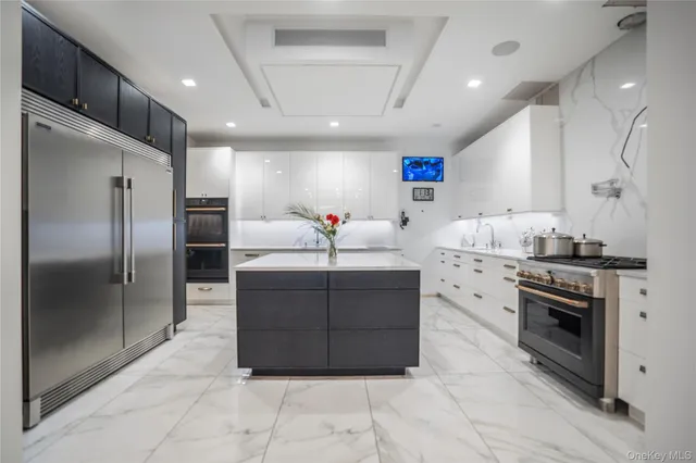 a kitchen with stainless steel appliances kitchen island granite countertop a refrigerator oven a sink and dishwasher