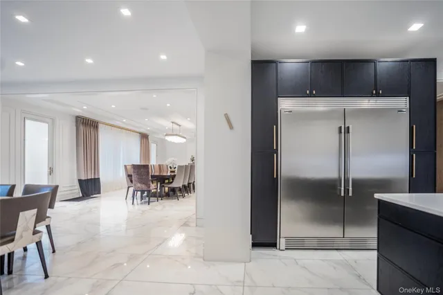 a kitchen with refrigerator and chairs