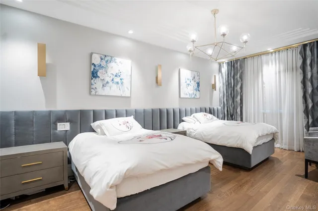 a spacious bedroom with two beds and a chandelier