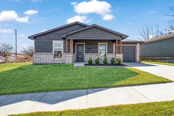 a front view of a house with a garden and plants