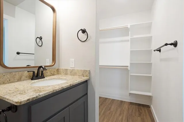 a bathroom with a granite countertop sink and a mirror