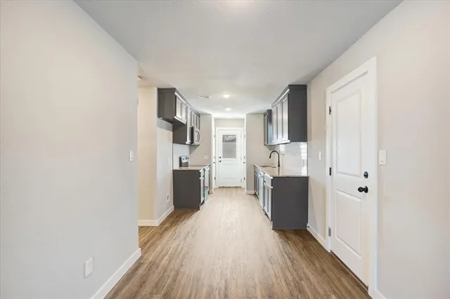 a view of a kitchen with a refrigerator and a stove top oven