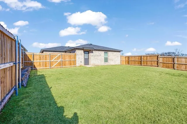 a view of a backyard with a garden and deck