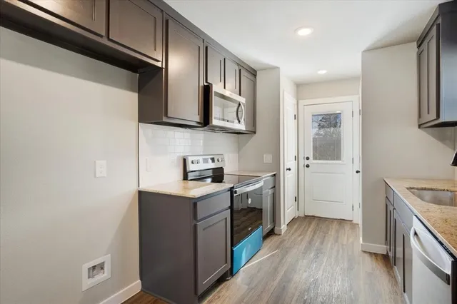 a kitchen with stainless steel appliances granite countertop a refrigerator a stove top oven a sink and dishwasher