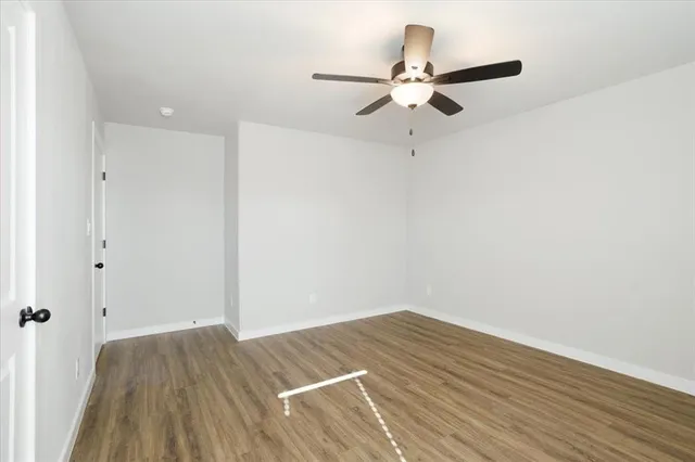 a view of a room with wooden floor and fan