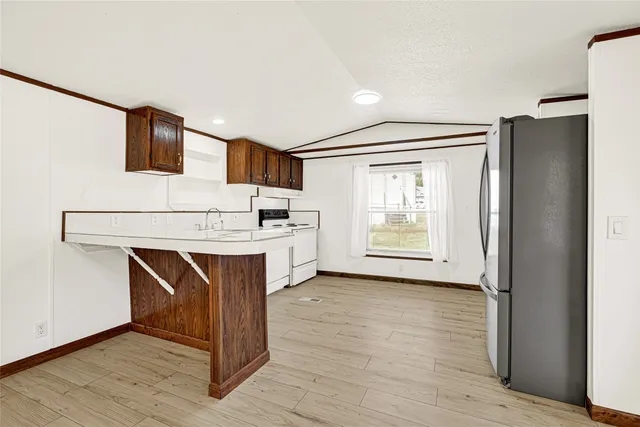 a view of kitchen with wooden floor and electronic appliances