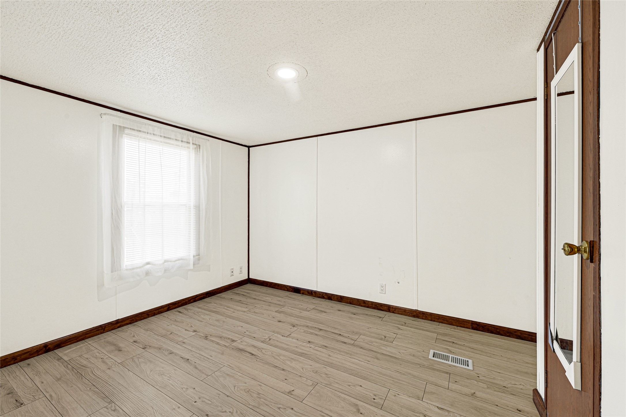 16794 Balmoral Street Montgomery, TX 77316 - Photo 17 of 24 a view of an empty room with wooden floor and a window