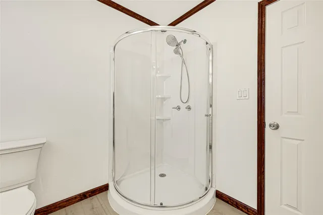 a bathroom with a shower a toilet and a sink