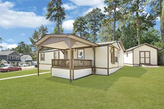 a view of a white house with a yard and deck