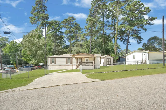 a front view of a house with a yard and trees