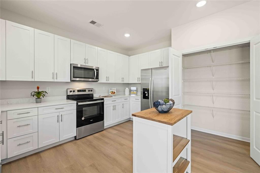 3489 Fairview Road, Unit MAGNOLIA Covington, GA 30016 - Photo 6 of 29 a kitchen with granite countertop white cabinets and stainless steel appliances