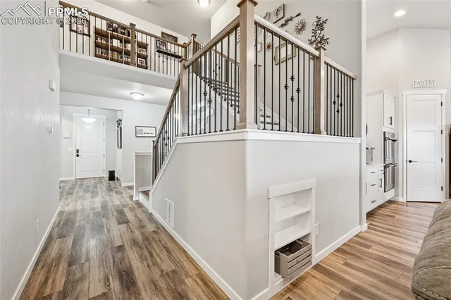 a view of a hallway with wooden floor and staircase