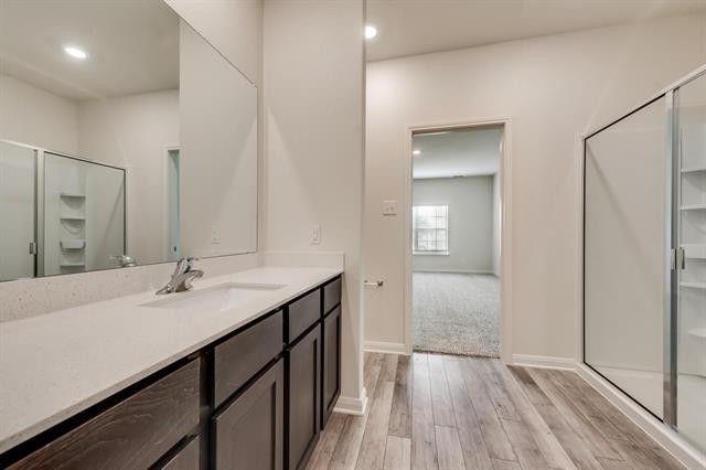 13609 Mineral Road Ponder, TX 76259 - Photo 20 of 21 Bathroom vanity featuring a light-colored countertop with an integrated sink and chrome faucet, dark wood-finish cabinetry, and a large wall-mounted mirror