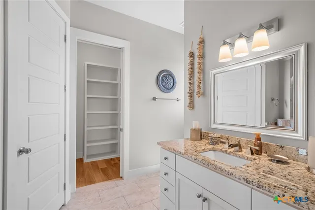 a bathroom with a granite countertop sink and a mirror