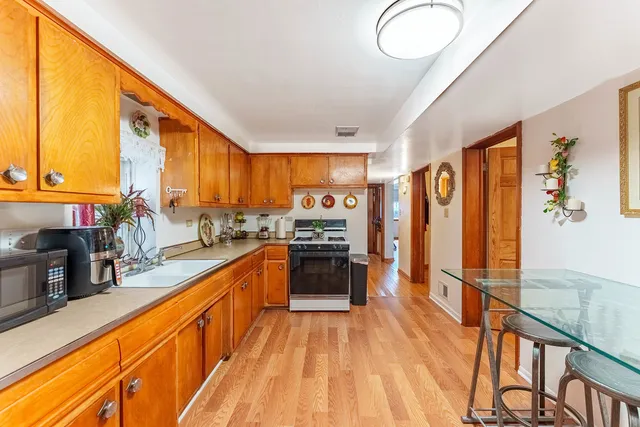 a large kitchen with stainless steel appliances granite countertop a large window and a refrigerator