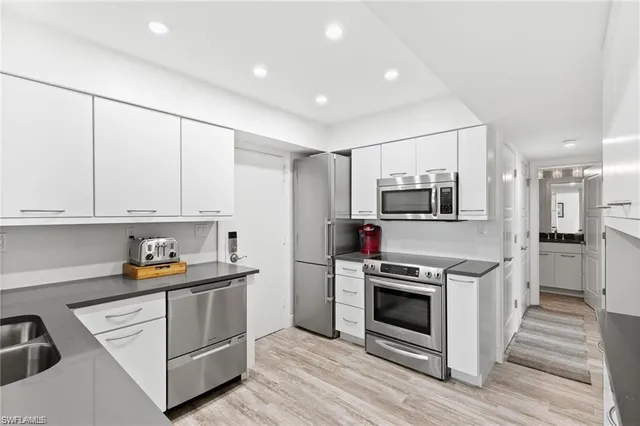 a kitchen with stainless steel appliances a stove sink and microwave