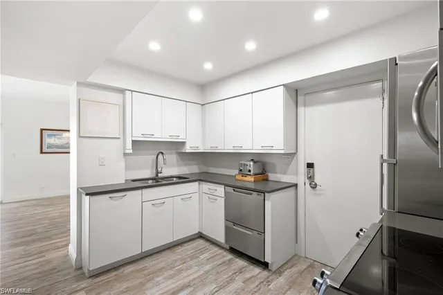 a kitchen with a sink a refrigerator and cabinets