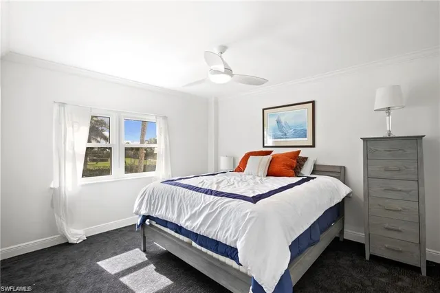 a bedroom with a bed next to a window and a chandelier