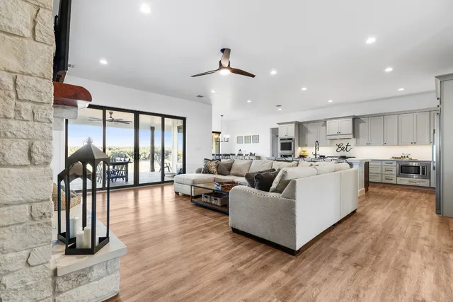 a kitchen with stainless steel appliances a stove a sink a oven a dining table and chairs