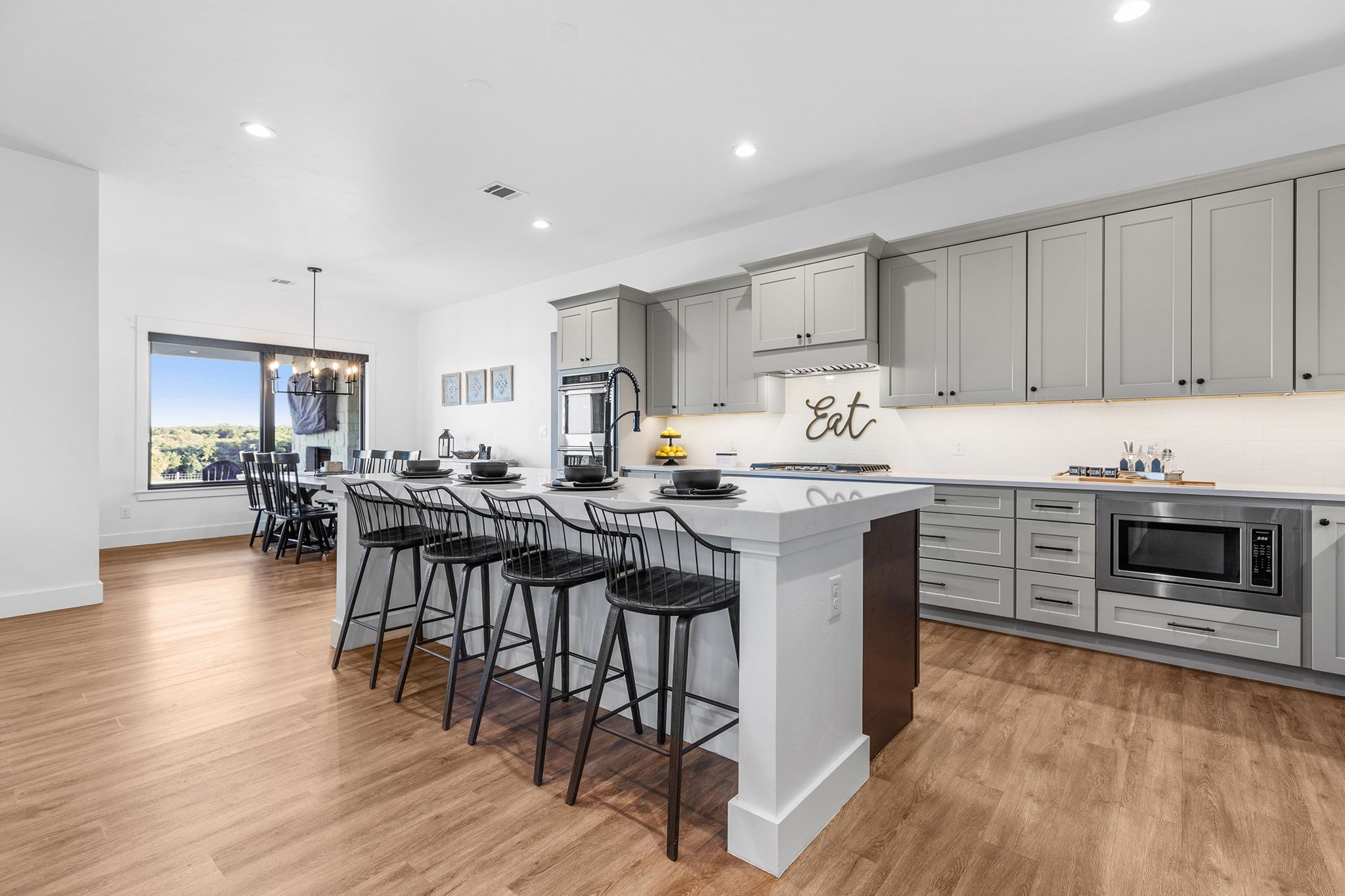 345 Judge's Road Burnet, TX 78611 - Photo 9 of 40 a kitchen with stainless steel appliances a stove a sink dishwasher a microwave oven and a dining table with wooden floor