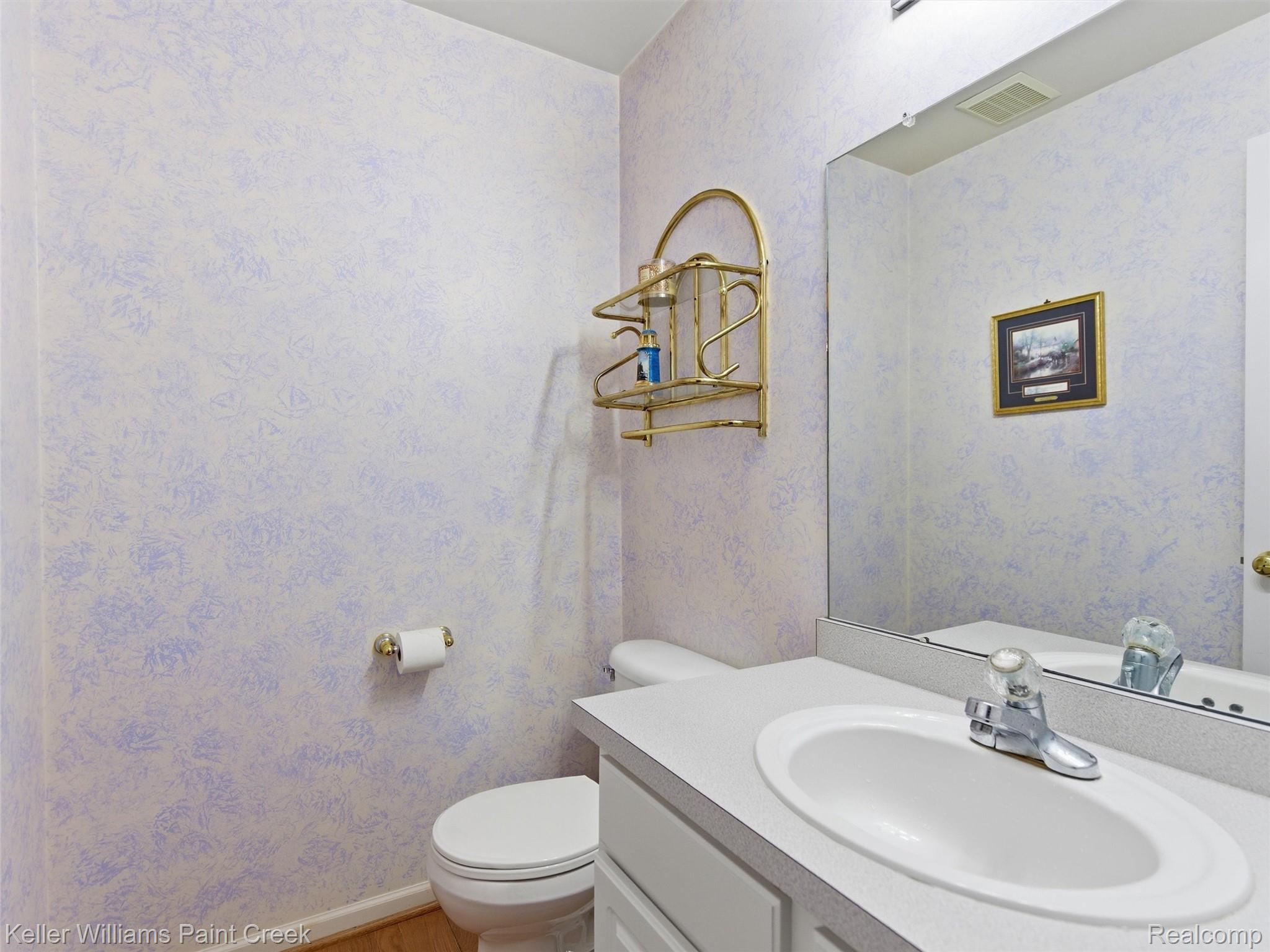 2842 Manorwood Road Troy, MI 48085 - Photo 41 of 72 Bathroom featuring a white vanity with an integrated sink, polished chrome faucet, and a large wall-mounted mirror