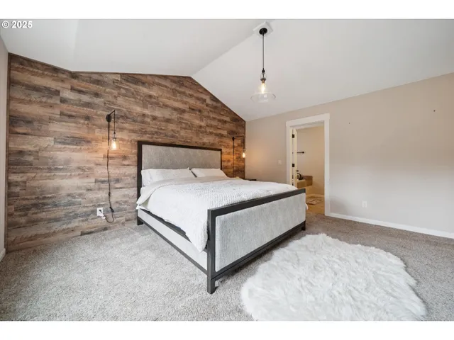 a large bed sitting in a room next to a lamp