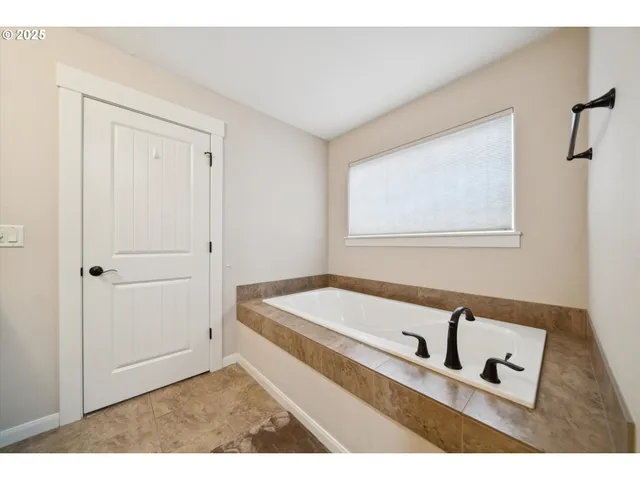 a bathroom with a bathtub and a window