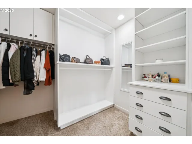 a view of walk in closet with clothes and shoes