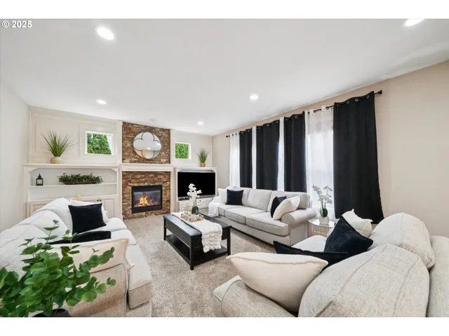 a living room with furniture a fireplace and a large window
