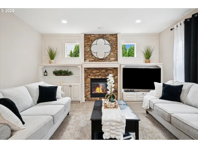 a living room with furniture a fireplace and a flat screen tv