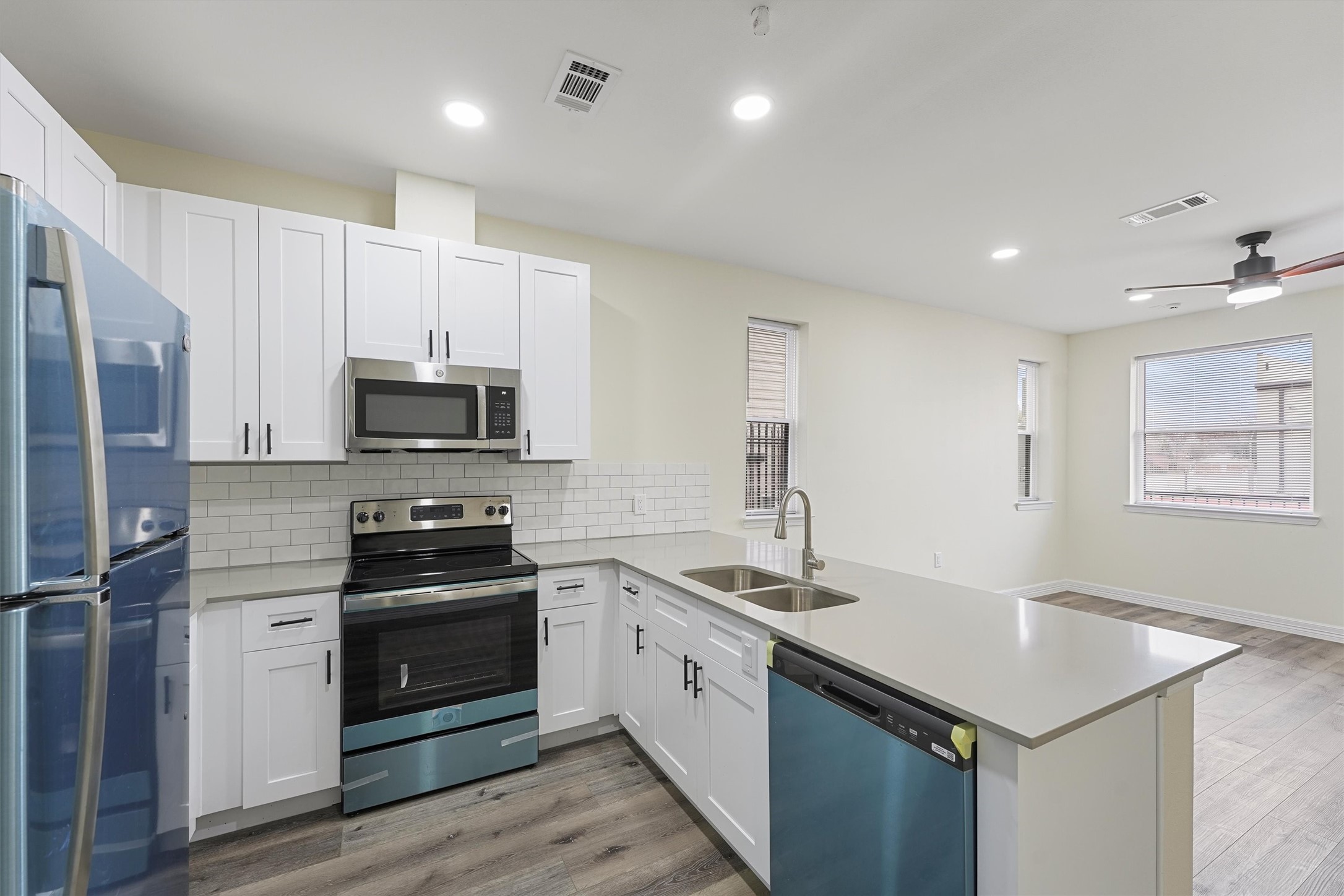 a kitchen with white cabinets stainless steel appliances and sink