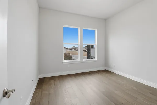 a view of a room with wooden floor and window