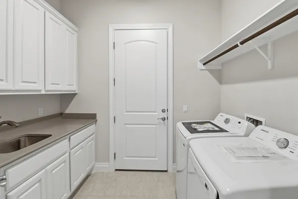 a utility room with sink dryer and washer