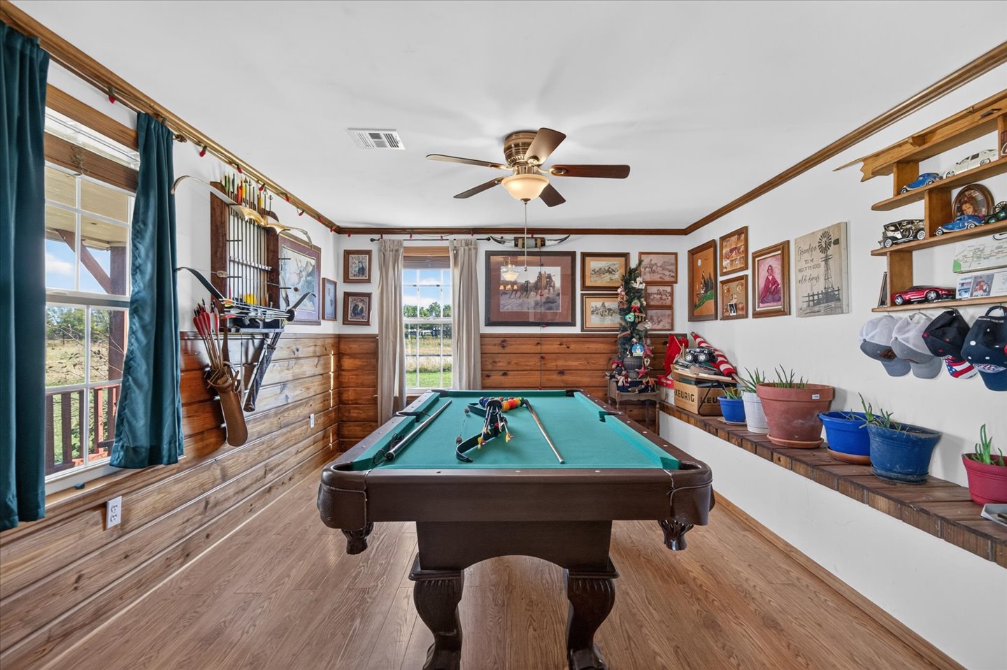 26115 4157th Road Nowata, OK 74048 - Photo 12 of 36 Room featuring wood-finish flooring, wood paneling, and a ceiling fan with integrated lighting