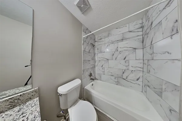 a bathroom with a toilet and a bathtub