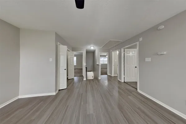 a view of an empty room with wooden floor