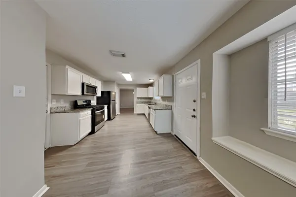 a large kitchen with cabinets and stainless steel appliances