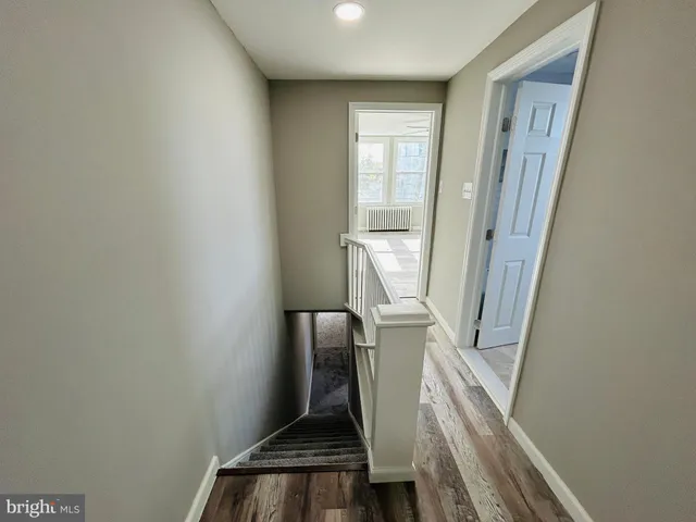 an empty room with windows and a ceiling fan