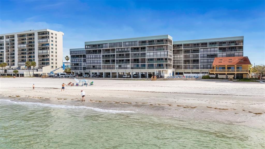 14900 Gulf Boulevard, Unit 410 Madeira Beach, FL 33708 - Photo 54 of 76 a front view of a building with glass windows and a yard