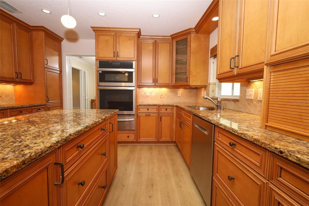 102 Pineview Court Altamonte Springs, FL 32714 - Photo 13 of 59 a kitchen with stainless steel appliances kitchen island granite countertop a refrigerator a stove and a sink with cabinets