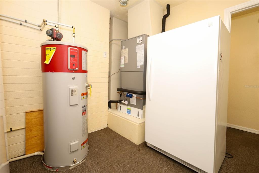 102 Pineview Court Altamonte Springs, FL 32714 - Photo 33 of 59 a utility room with fridge and wooden floor