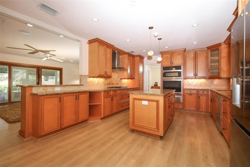 102 Pineview Court Altamonte Springs, FL 32714 - Photo 10 of 59 a kitchen with stainless steel appliances granite countertop a stove a sink dishwasher a refrigerator and white cabinets with wooden floor