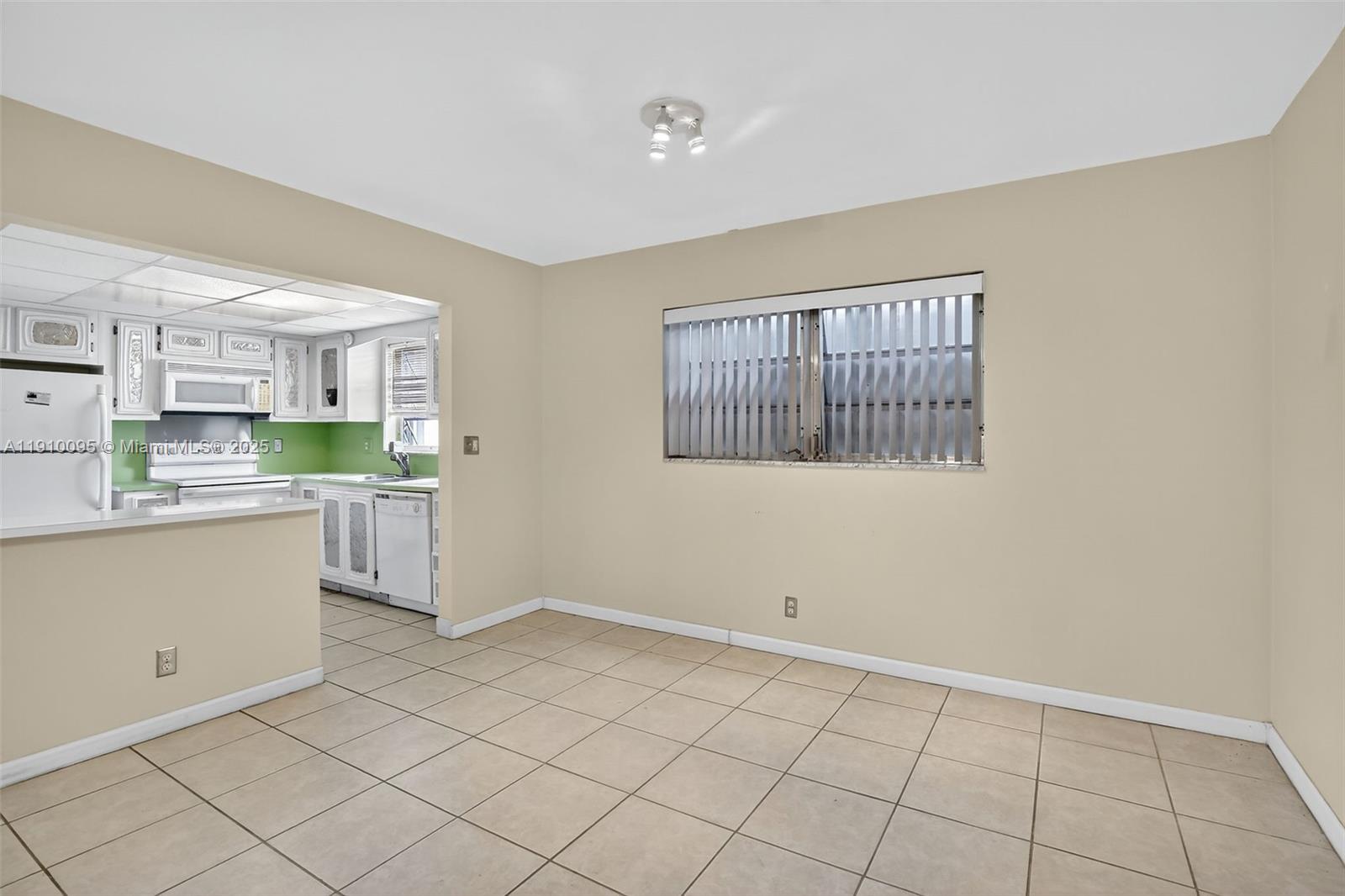 5300 Washington Street, Unit T218 Hollywood, FL 33021 - Photo 12 of 36 a kitchen with white cabinets and white appliances